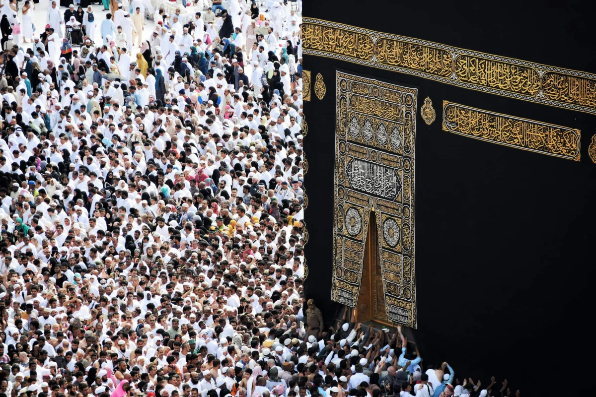 A large crowd of pilgrims gathered around the Kaaba decorated with gold calligraphy in Mecca.