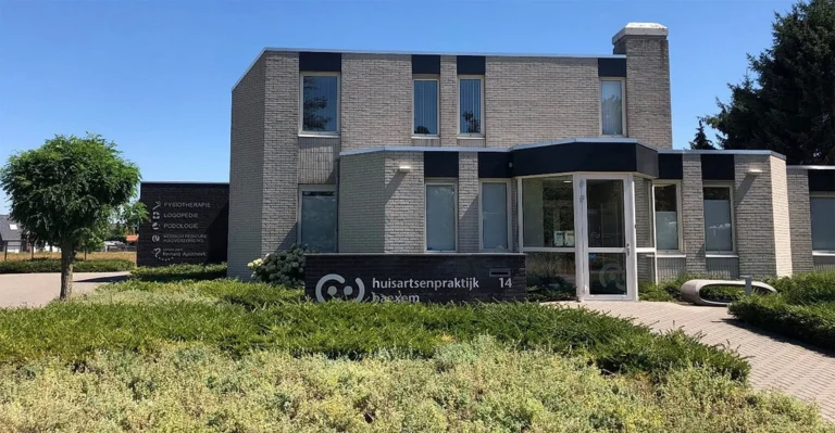 Exterior of Huisartsenpraktijk Baexem medical practice building with entrance sign and garden