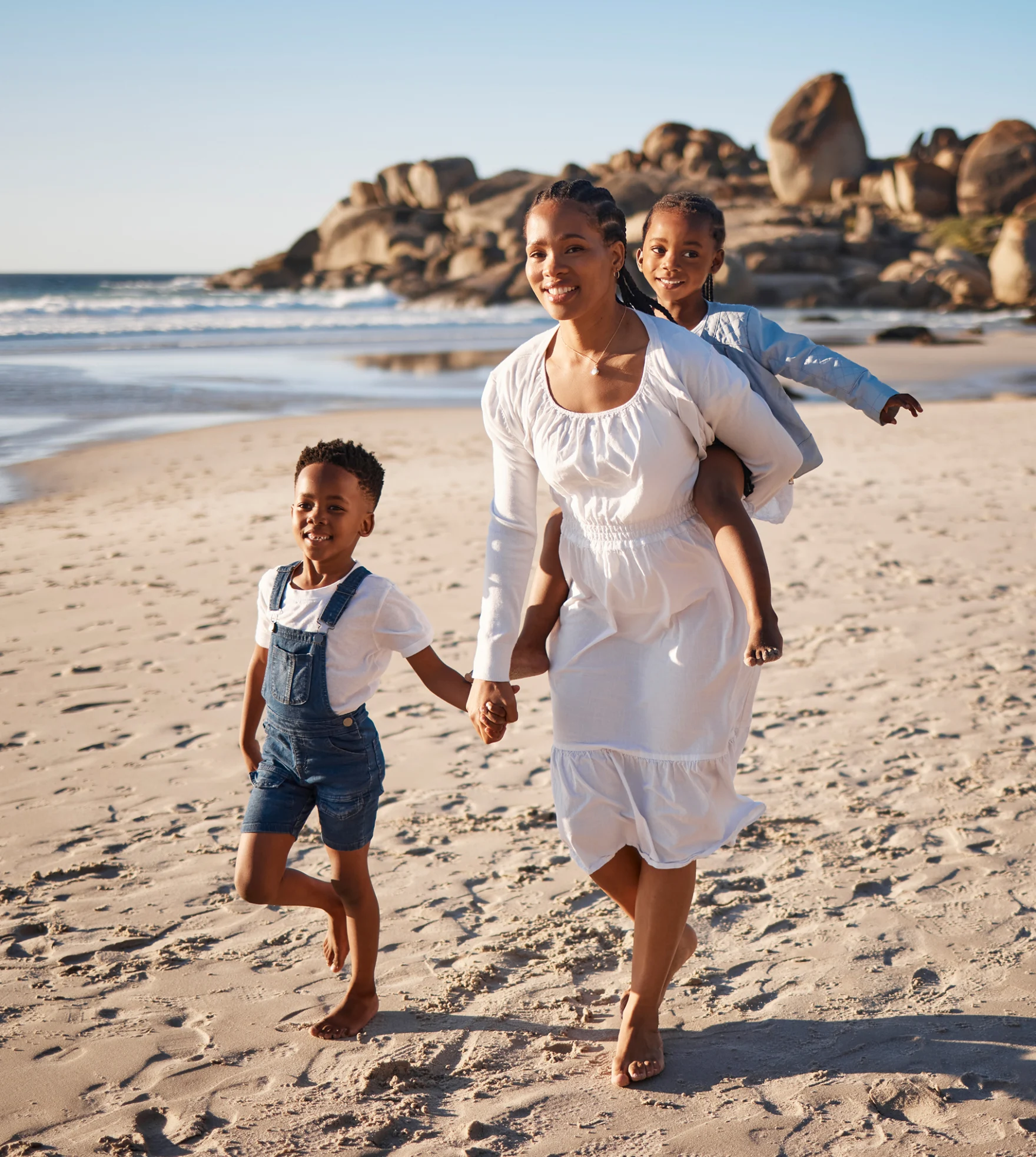 Ouders lopen hand in hand met hun kind door de branding