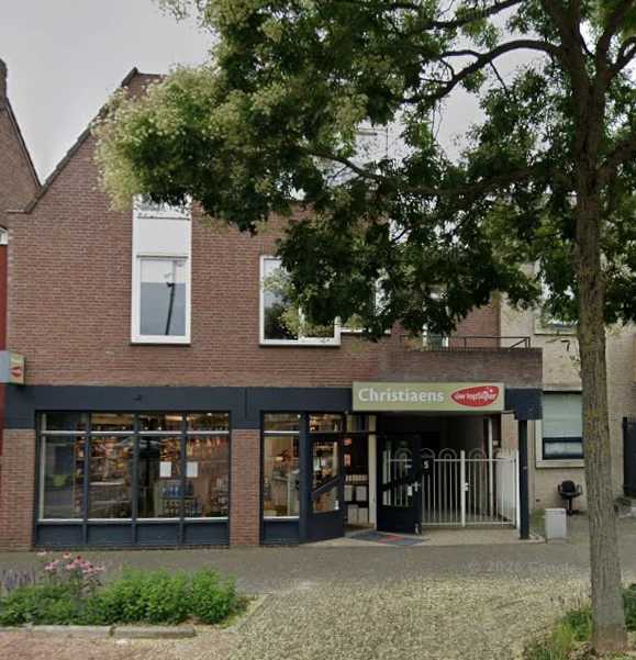 Christiaens opticians storefront on the ground floor of a two-story brick building