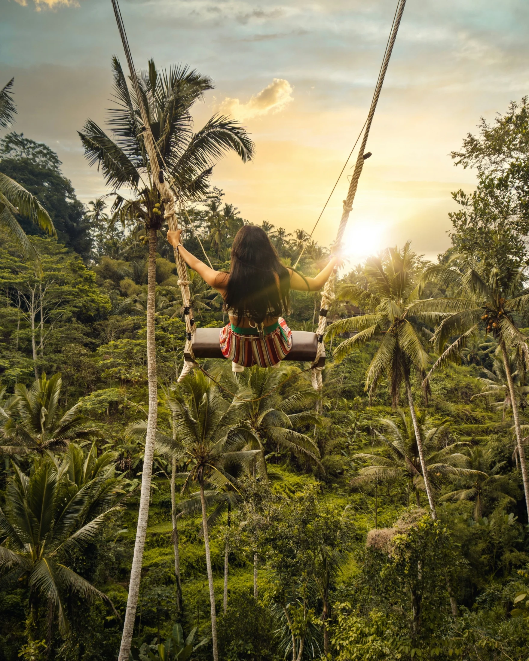 Reiziger op een schommel boven de jungle bij zonsondergang