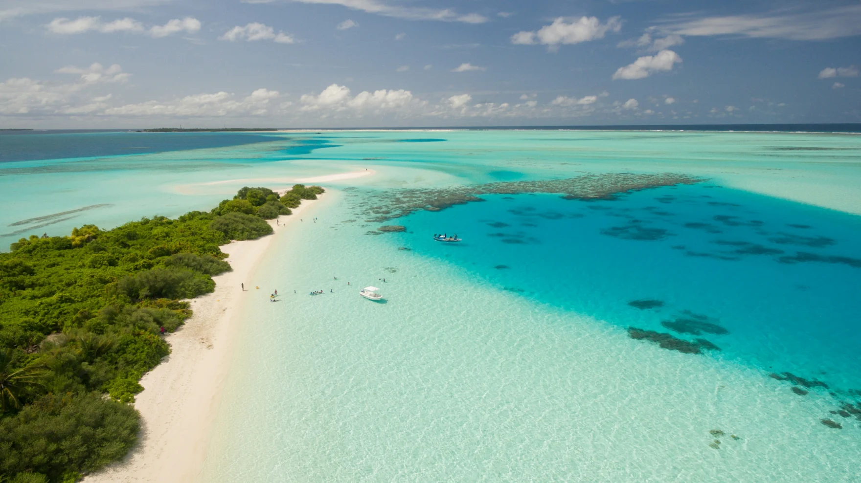 Tropisch atol met wit strand en turquoise water