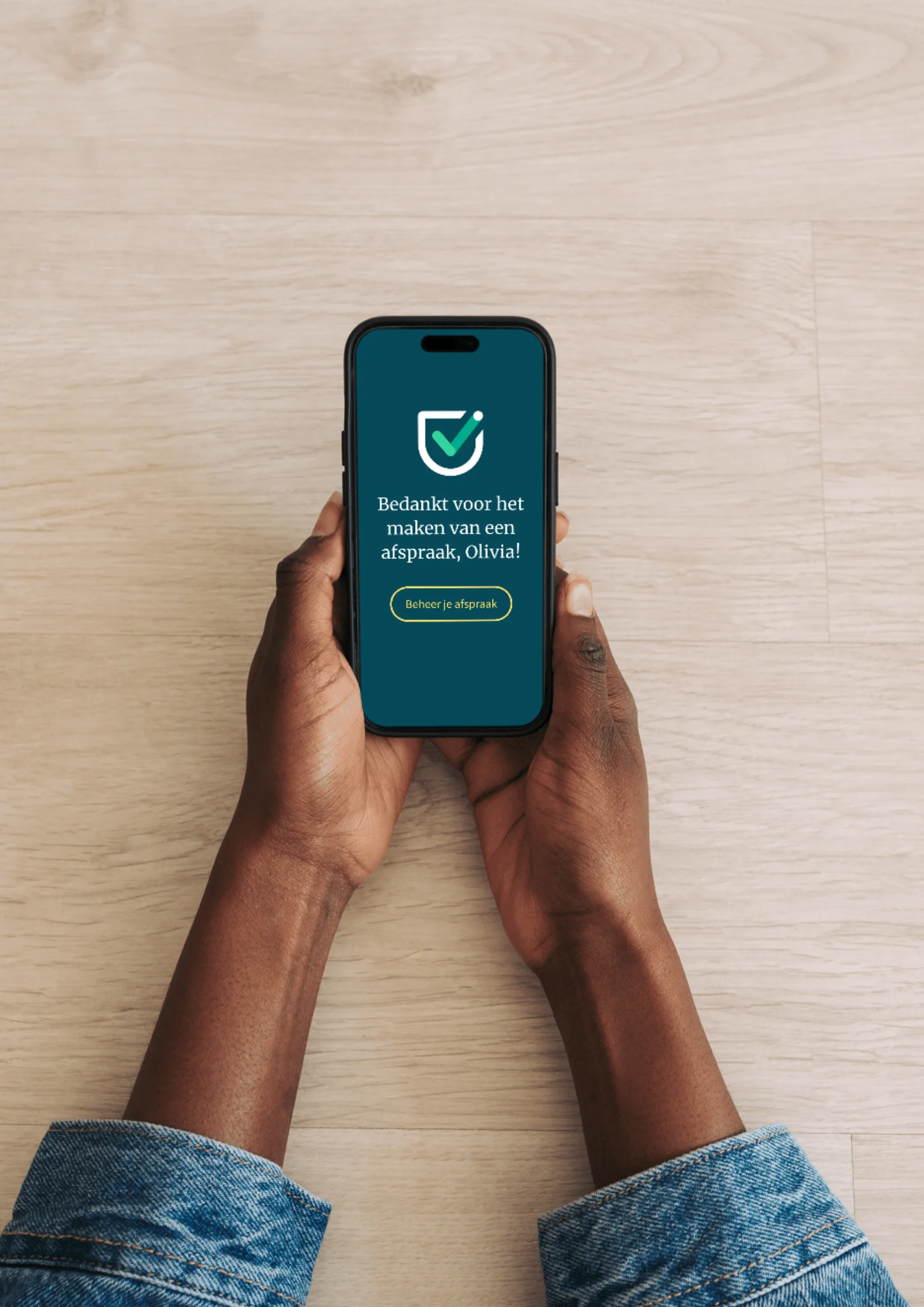 Handen met een telefoon waarop de Vaccinatiepunt-app staat