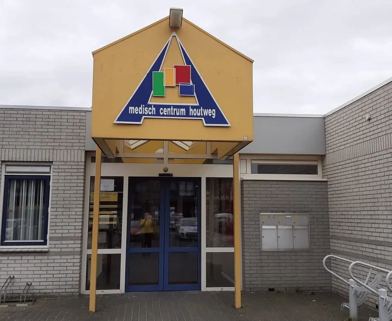 Entrance of Medisch Centrum Houtweg with a yellow canopy above the glass doors