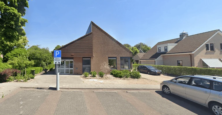 Exterior of a modern brick building with an angular roof and parking in Geldermalsen.