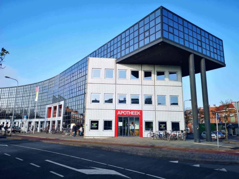 Modern building with a curved glass facade and pharmacy entrance in Groningen.