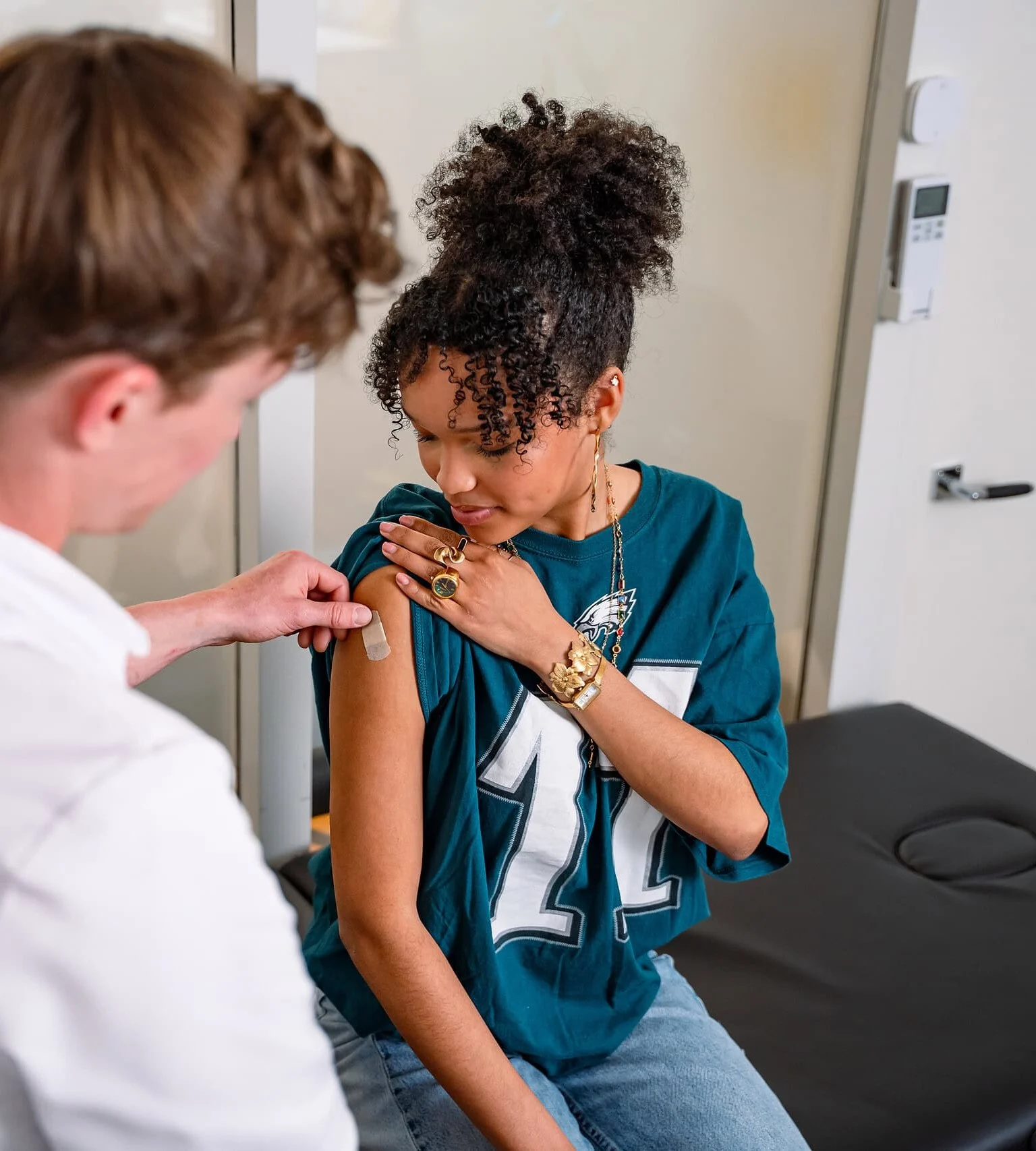 Vaccinatieverpleegkundige plakt een pleister na een vaccinatie