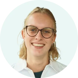 Smiling young woman with blonde hair wearing glasses and a white collared shirt