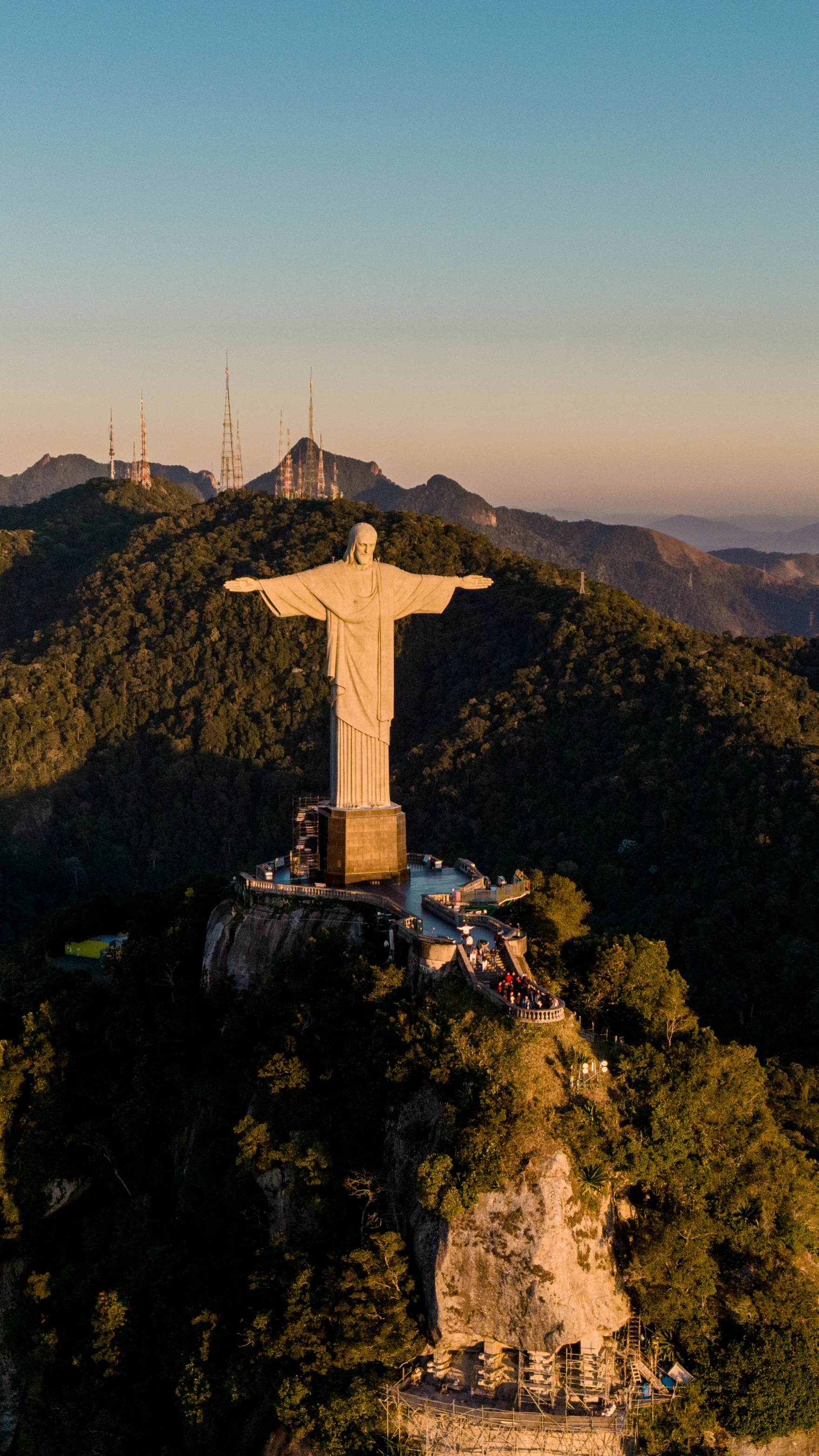 Christ the Redeemer statue atop Mount Corcovado overlooking lush forested hills in Rio de Janeiro